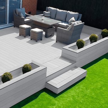 Premium light grey composite decking board enhancing an outdoor living space with modern furniture and greenery.