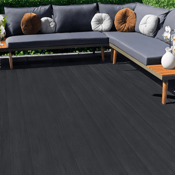 Dark grey composite decking beside an outdoor corner sofa