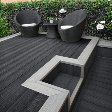 Grey composite decking with garden chairs and planted border