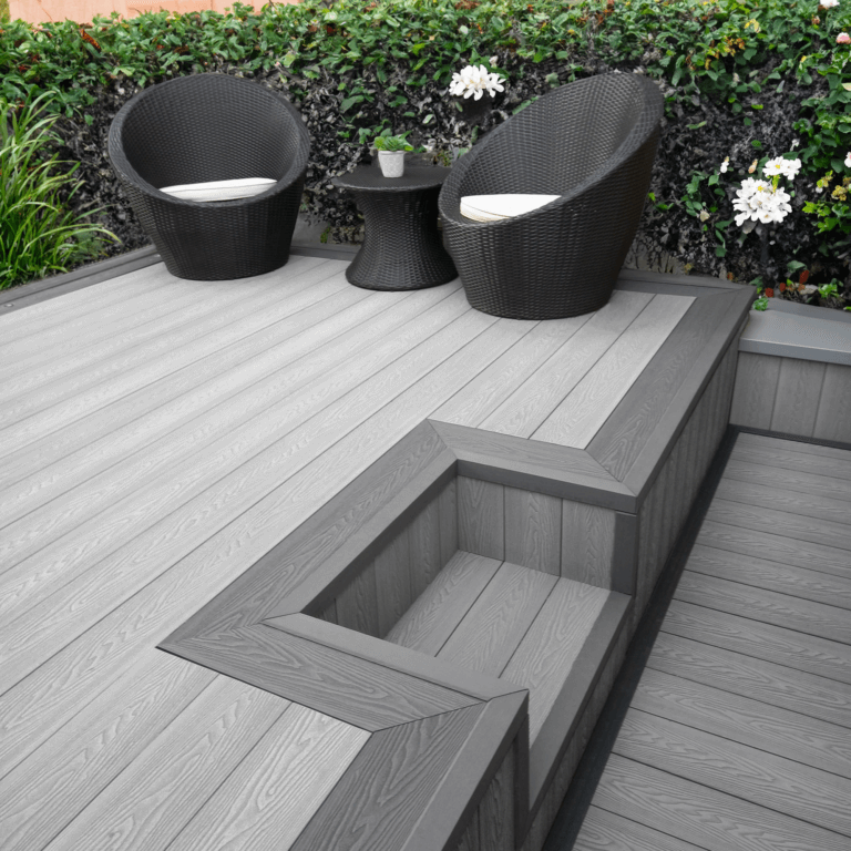 Elegant outdoor space featuring light grey composite decking, stylish chairs, and a modern design.